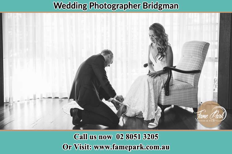 The Bride is being helped by the Groom trying to put on her shoes Bridgman NSW 2330