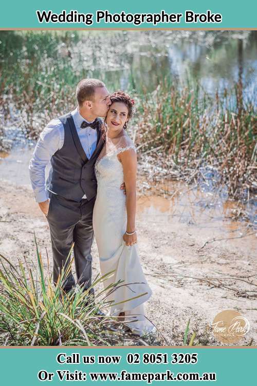 Photo of the Groom kiss the Bride near the lake Broke NSW 2330