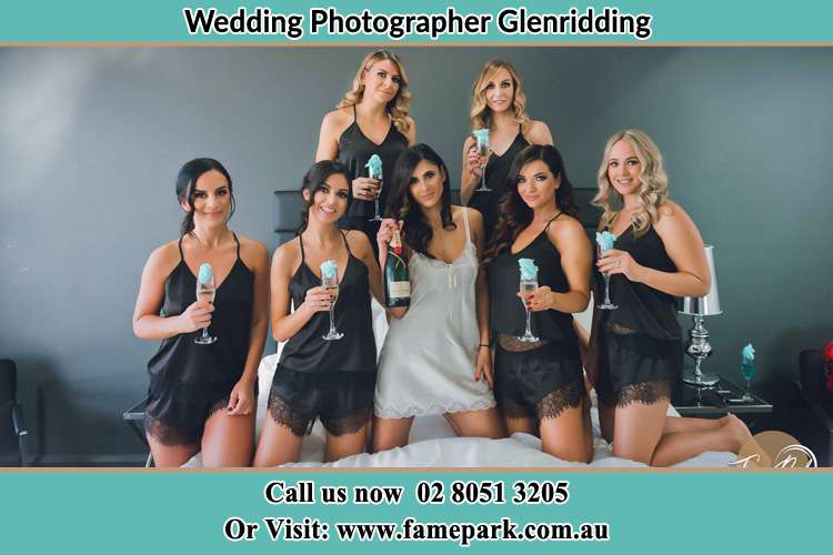 Photo of the Bride smiling on the bridesmaid holding the tail of her wedding gown at the front of the church Glenridding NSW 2330