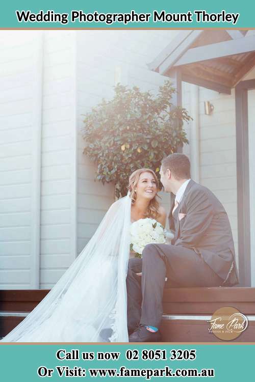 Photo of the Bride and the Groom looking each other while sitting at the staircase Mount Thorley NSW 2330