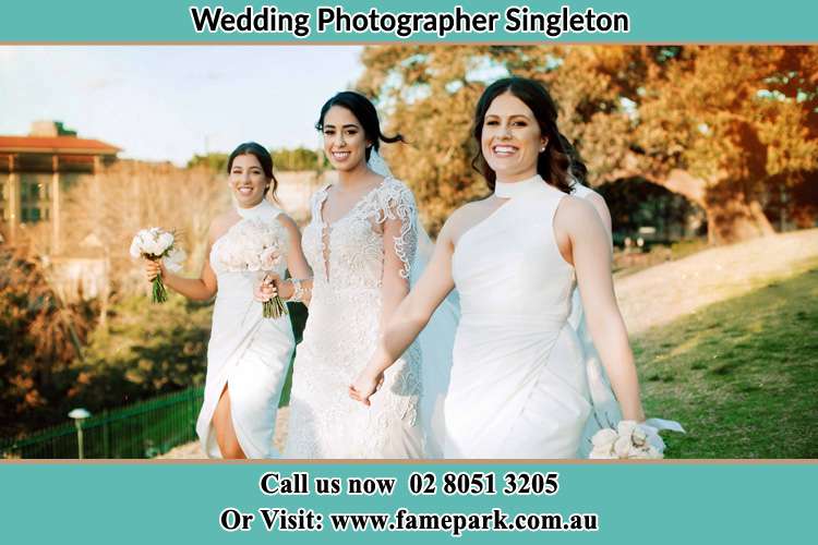 The Bride and her bridesmaids smiles as they walk Singleton